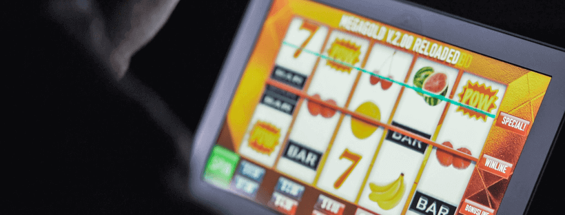 Australiër die op laptop pokies speelt